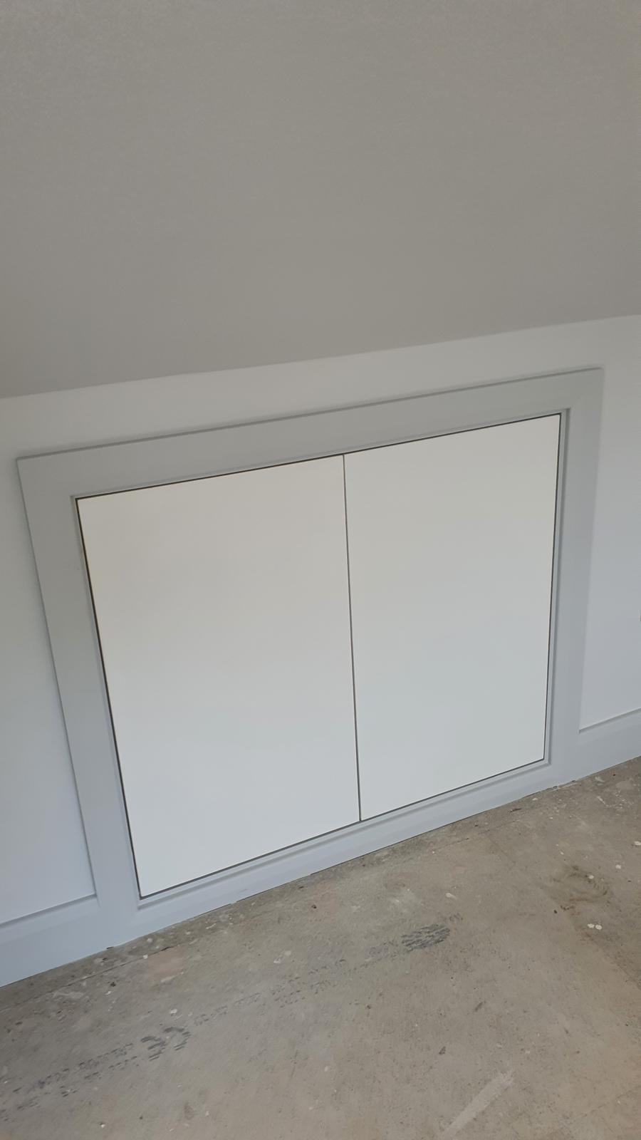 Clean white built-in storage unit with modern handle-less design