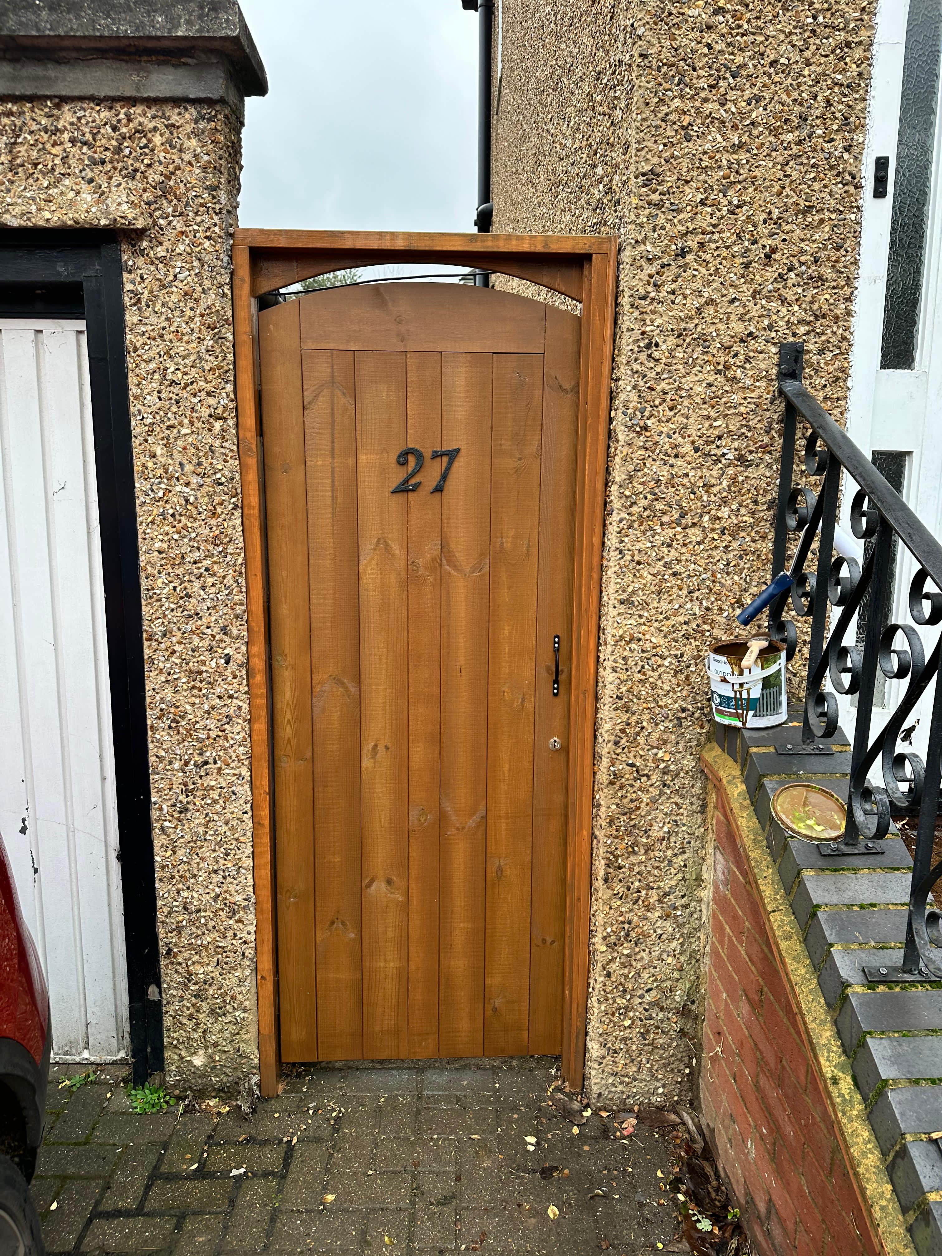 Bespoke wooden garden gate with arched top detail and house number